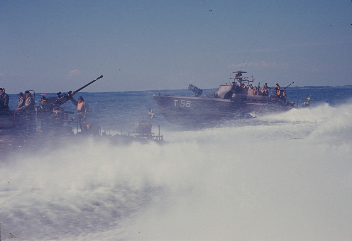 Bilden visar motortorpedbåten T 56 och en annan båt som kör bredvid varandra i hög hastighet.