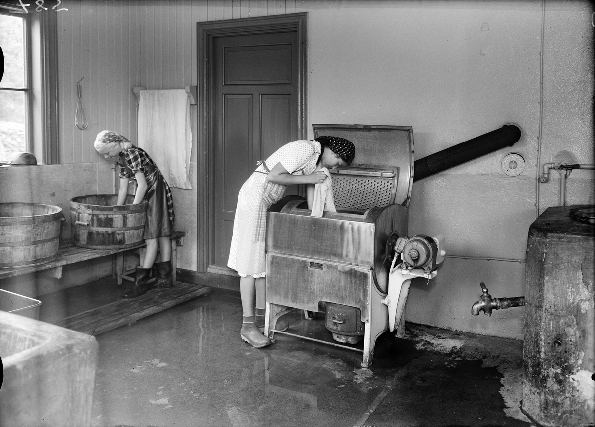 Två unga kvinnor i tvättstugan på Kumlans Lanthushållsskola, Uppland 1949