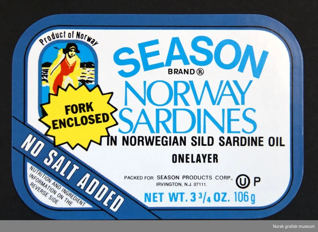 Etikett med hvit bakgrunn og blå ramme. Til venstre er en illustrasjon av en kvinne på stranden (?), under en gul stjerneformet figur. 

"Norway sardines in Norwegian sild sardine oil"