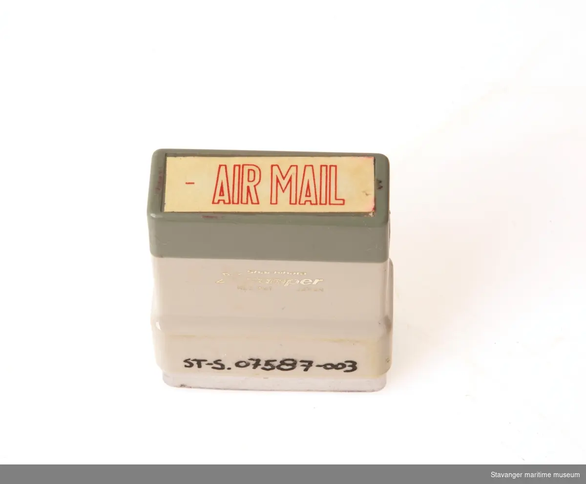 Stempel i plast og metall, hvor det står Air Mail.