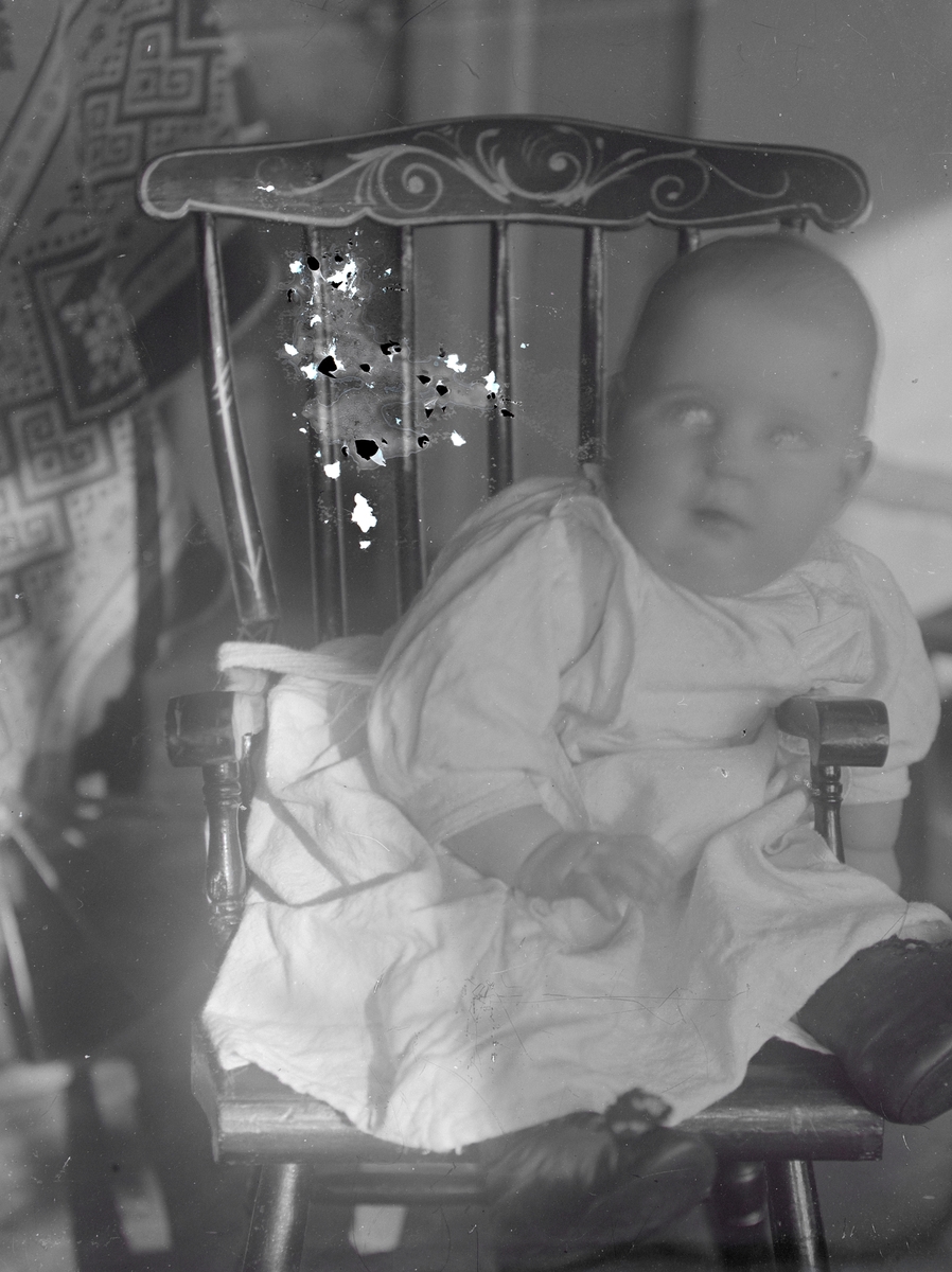 Portrett av en baby fra familien Aston som sitter på en stol.