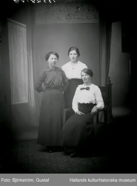 Ateljébild av tre unga kvinnor vid ett bord. Beställare: Alma Gunnarsson, Svenstorp 2, Derome. Se även bildnr GB2_4982.