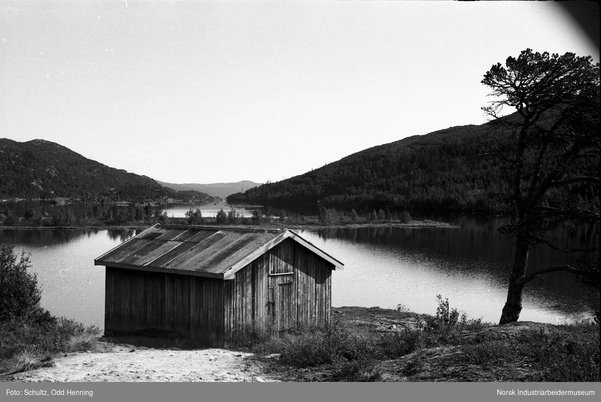 Brygga ved Frøystul Feriested. Et naust eller båthus ved vannet.