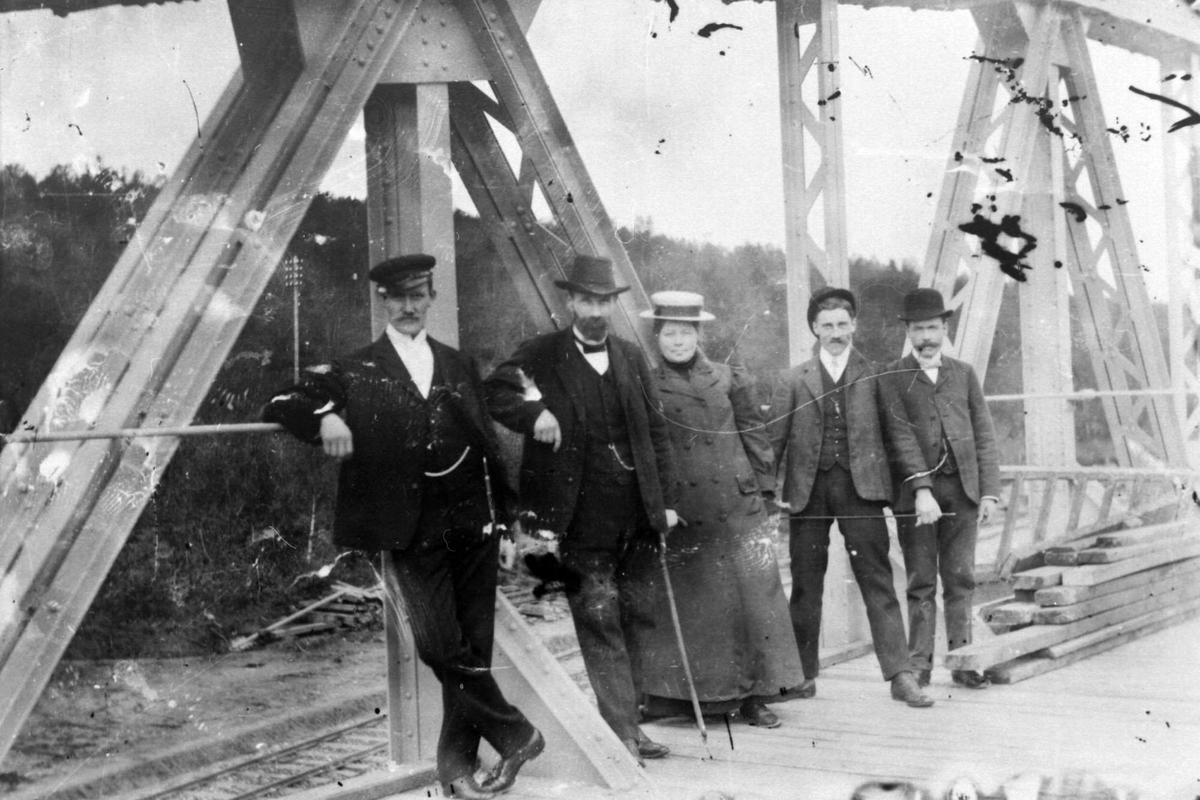 Fire menn og en kvinne på en bro.