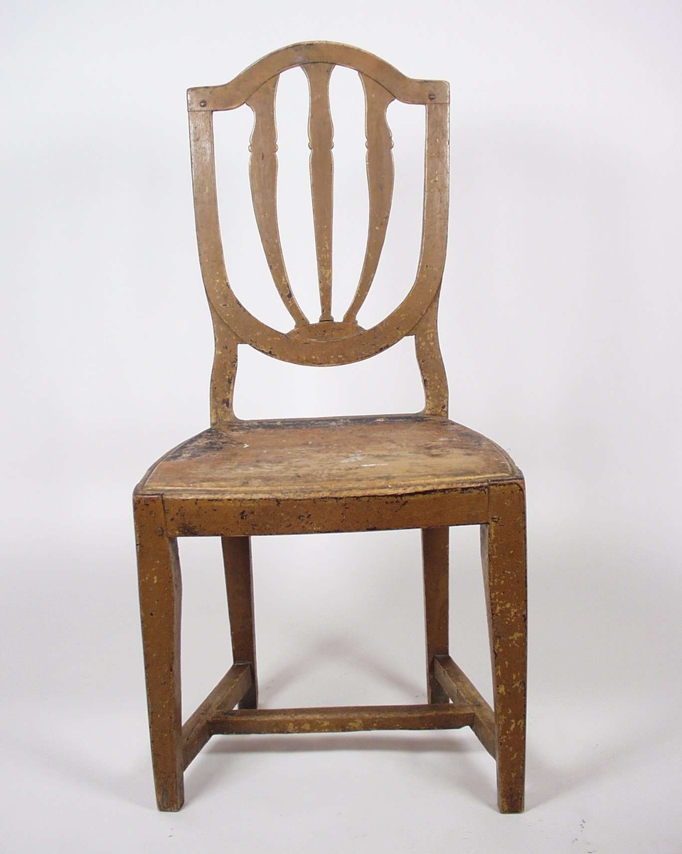 Stolen er av bjørk i ny-klassisistisk stil. Stolryggen er skjoldformet, gjennombrutt og løftet klar av setet.