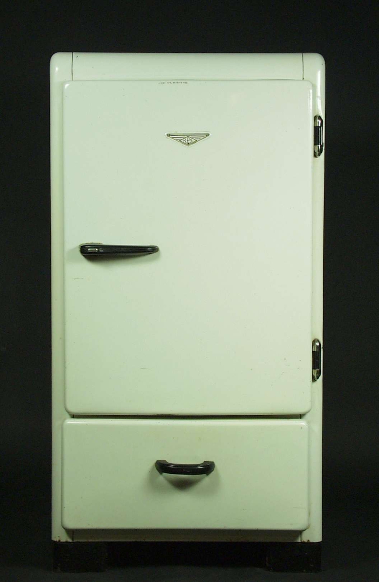 Et hvitt kjøleskap med grønnsakskuff nederst.
I skapet er det plass for en liten hylle og to vanlige hyller.
Det har to plasthåndtak i sort farge og hengsler i metall.