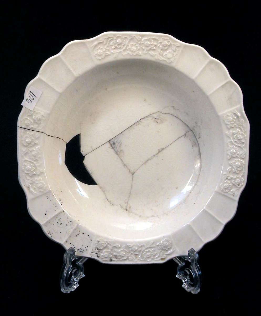 Elfenbenshvit glasert dyp tallerken med dekor i relieff.