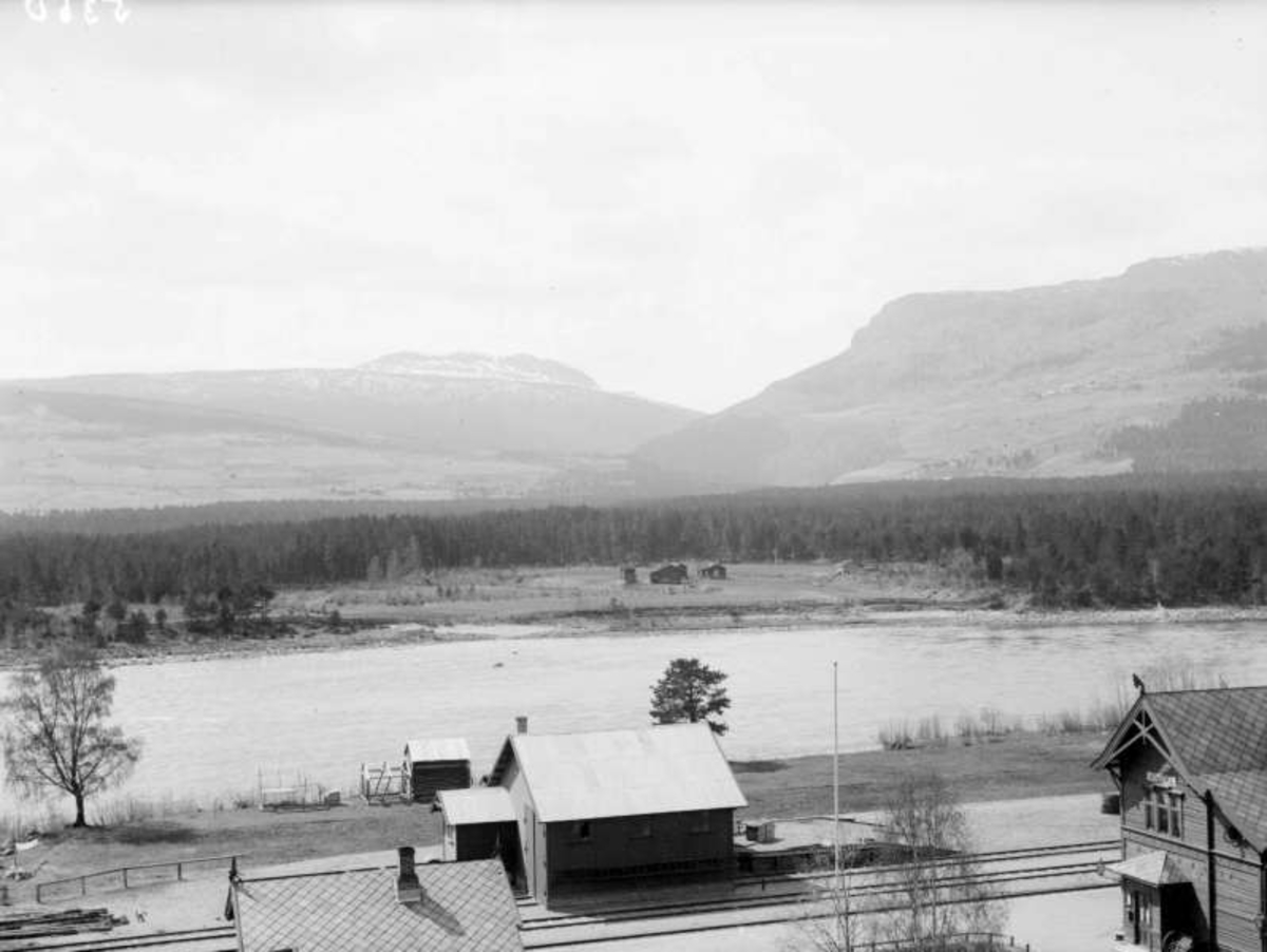 Utsikt fra fotografens bolig Fronheim 1/6-1900,  i forgrunnen Vinstra stasjon ved elva Gudbrandsdalslågen. fjellet Feforkampen, småbruket Odden ved elva, skogområdet Lomoen.