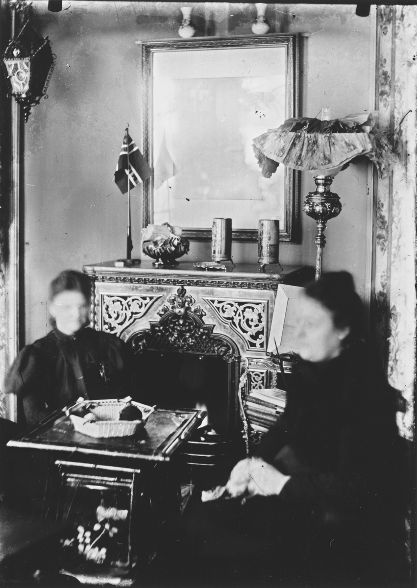 Kvinner med håndarbeide foran peisen. 