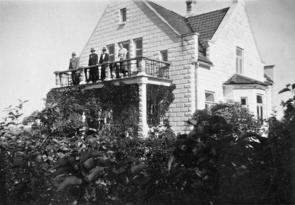 Flere personer står på veranda i bolig med hage i Gml. Strømsveien 74. 1940