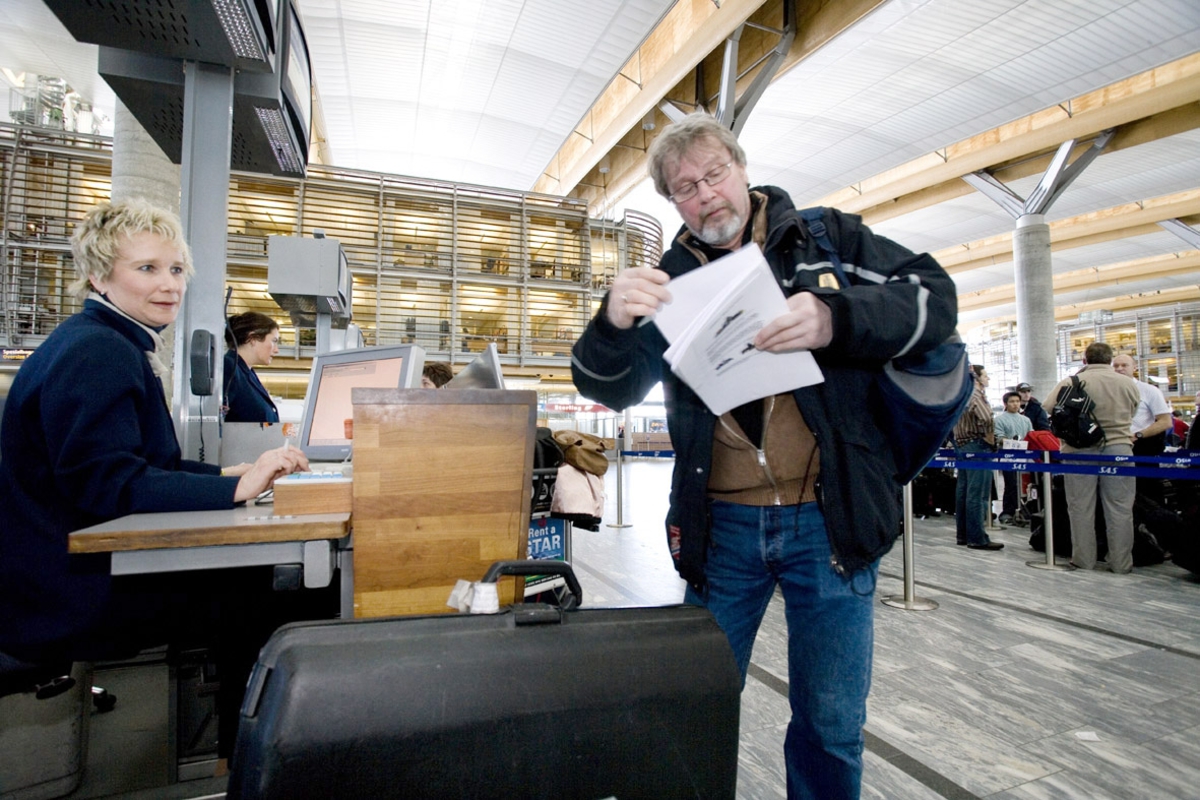 Vesker. Innsjekking. Mannlig reisende sjekker inn bagasjen. Fotodokumentasjon i forbindelse med dokumentasjonsprosjekt - Veskeprosjektet 2006 - ved Akershusmuseet/Ullensaker Museum. 