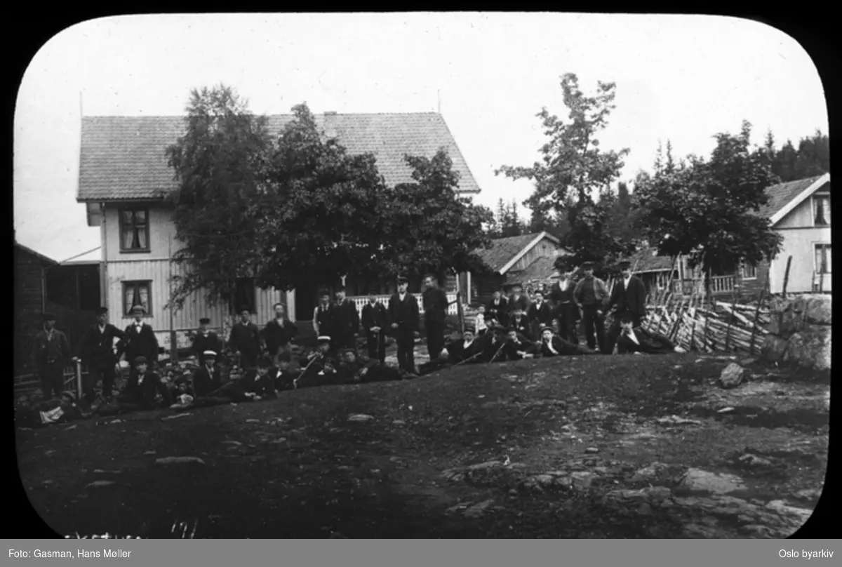 En gruppe menn og ungdommer i penklær poserer for fotografen ved Kleivstua, 17. august 1902