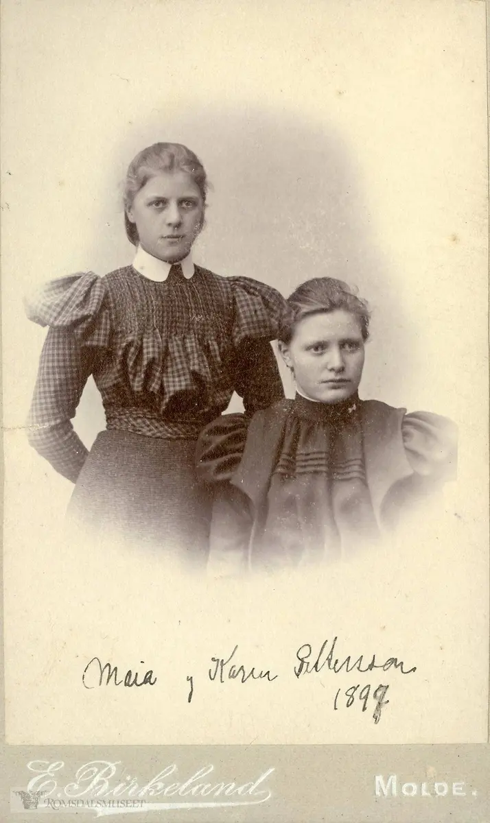 Piken til venstre på bildet er Marie Pettersson (Maia), f.1883, til høyre Karen Pettersson - de er søstre, begge døtre av Samuel Pettersson og hustru Anne. Marie Pettersson ble gift med handelsskolebestyrer Peder Wang (1873-1937) som startet Wangs handelsskole i Oslo (Kristiania) i 1907.