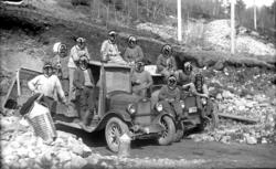 Gamle lastebiler og veiarbeidere på arbeid i grushålen på Yt