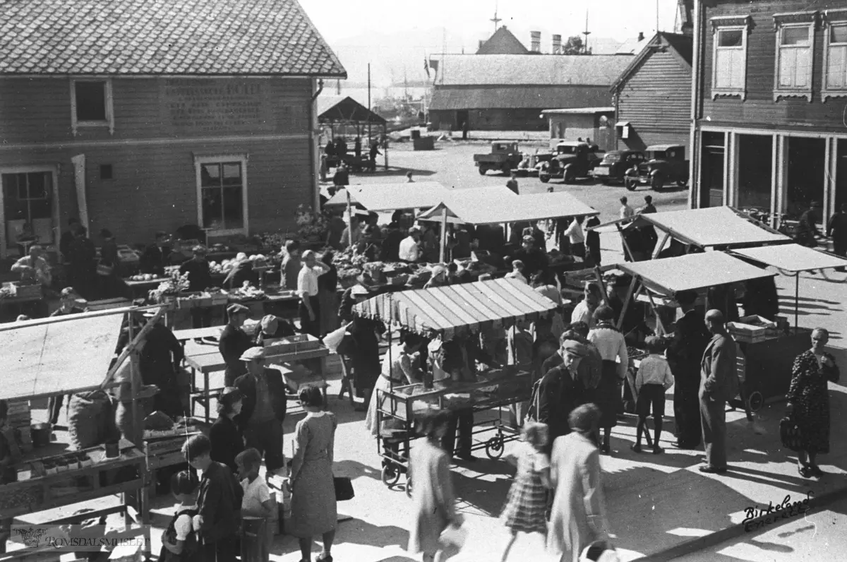 Torgdag i Molde i 1930 årene ved havna i Molde. Til venstre ses Romsdals Dampskipsselskaps gård i Molde.