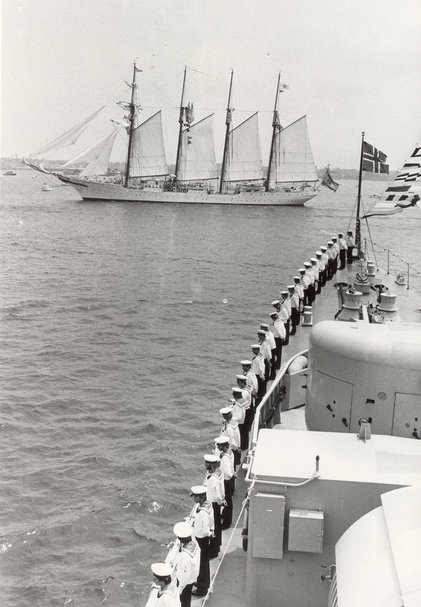 Enkeltbilde. Fregatten KNM Trondheim, besøker New York under 200-års jubileum 4/7-1976. Oppstilt for manning av relling. I bakgrunnen den spanske toppseilskonnert "JUAN SEBASTIAN DE ELCANO" som deltok i Operation Sail