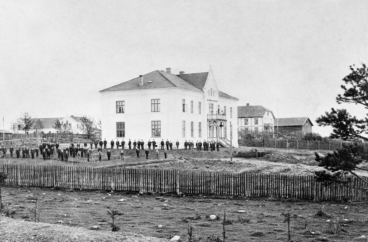 Hamar Lærerskole, Hamar Stiftsseminarium, skolen startet opp i 1867, de nye skolebygningene på fotografiet sto ferdig i 1877, til venstre ligger gymniastikkbygningen og til høyre hovedbygningen til Holset gård, oppstilte elever bak stakitten, 
