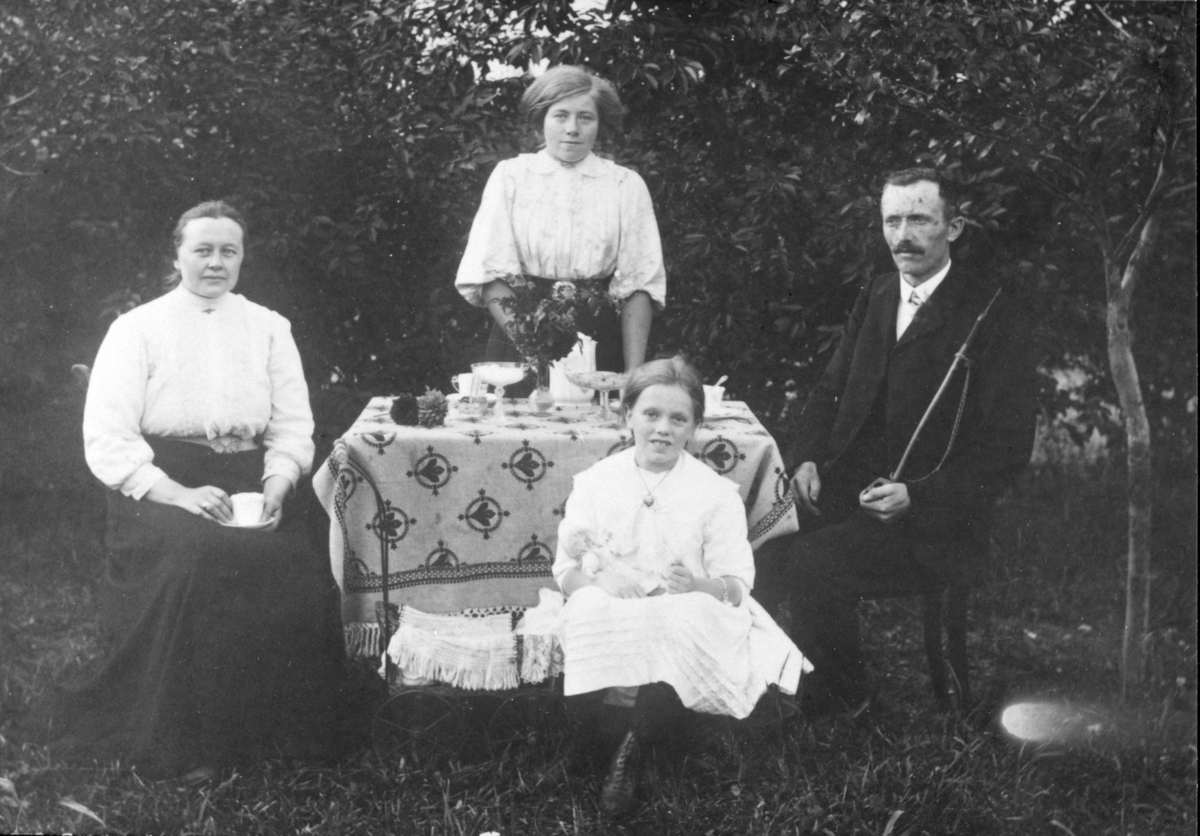 Lærer Peter Sønstevold på Penningrud skole, Stavsjø (1913-1918) med hustru og datteren Grete. Jenta bak er trolig en tjenestejente.