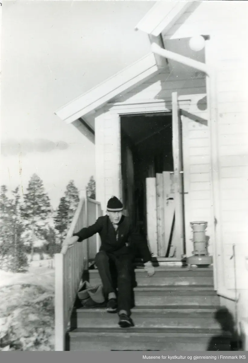 Karl-Arne Fredheim sitter på en trapp i Alta 1955. Han er bosatt i Mehamn. Gamvik Kommune.