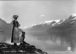 Kvinne og jente i bunad ved Sørfjorden, ukjende