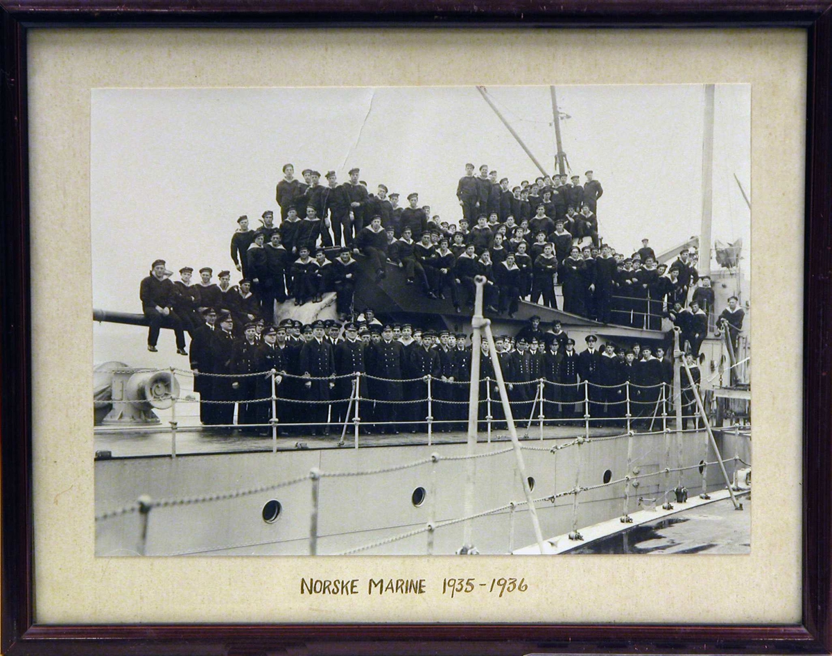 Gruppebilde av den norske marine 1935-36 (iallfall en god del av dem) stående på dekk på et marinefartøy ved kai.