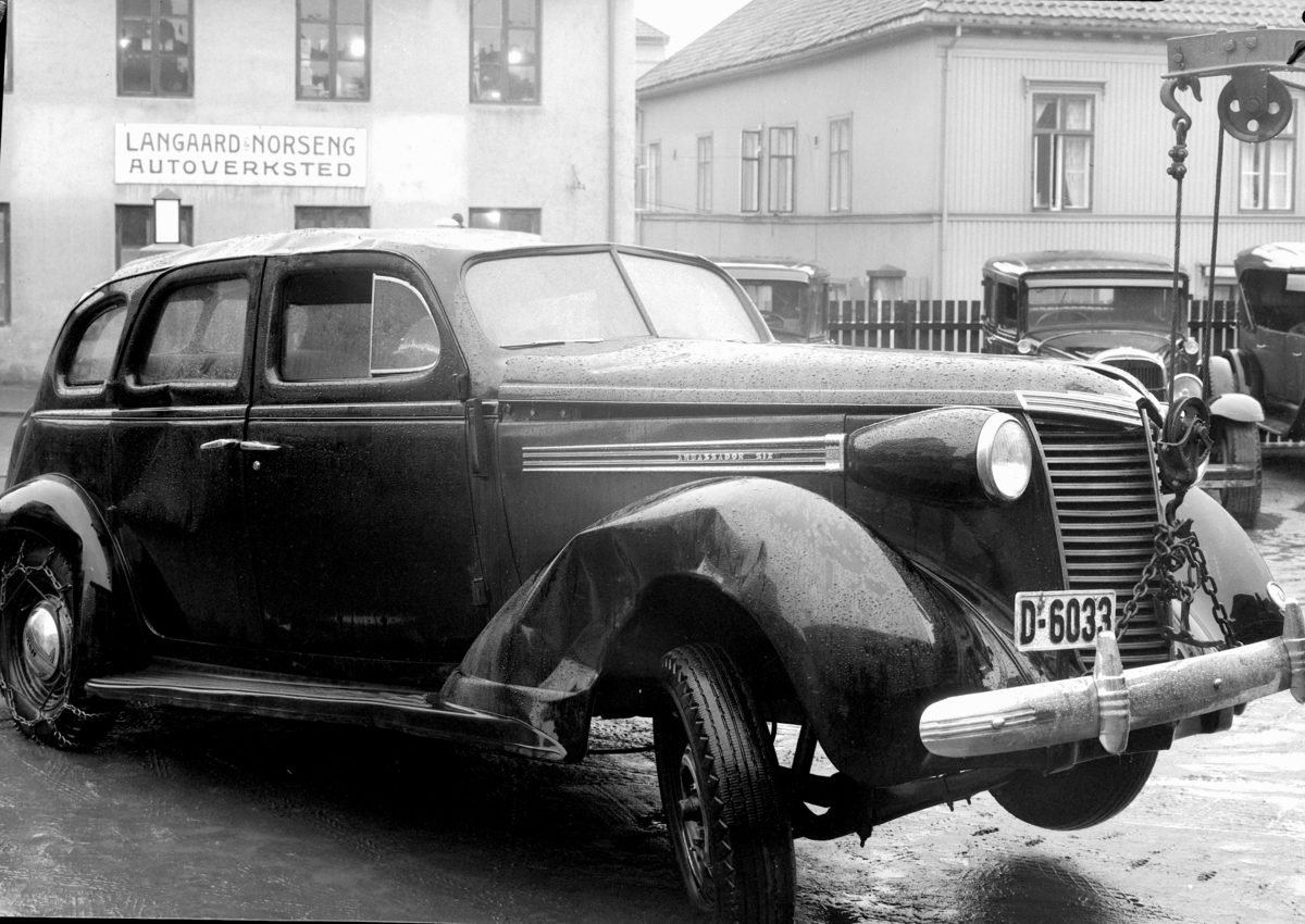 Oplandske Auto. Kolisjonskadet bil, D-6033. Hamar. 
Nash 1938. Kan tidligst være fotografert senhøsten 1938. Ambassador Six. 
Iflg. Hvem eier bilen 1947 sto skiltet da på D-6033 da på Ford personbil tilh. Rena Pappfabrikk. 