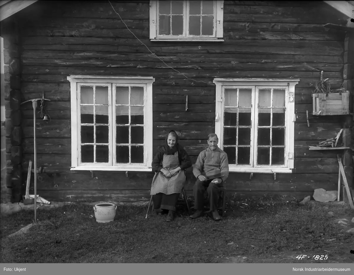 Jon og Hege Kromviki sitter mot husvegg på Kromviki, Møsstrond