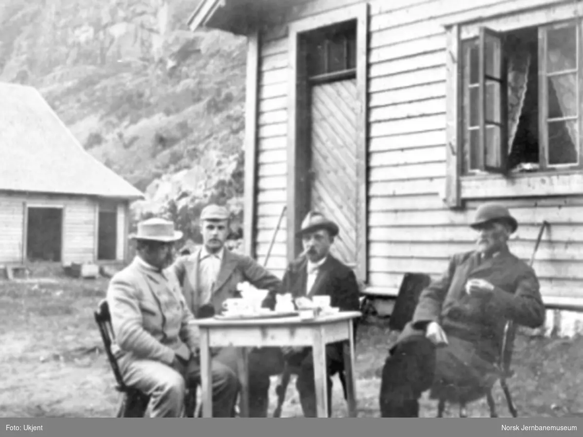 Ingeniørene Swenningsen, Matheson, Saxegaard og overing. Lekve ved kaffebordet utenfor en anleggsbrakke i Kårdalen