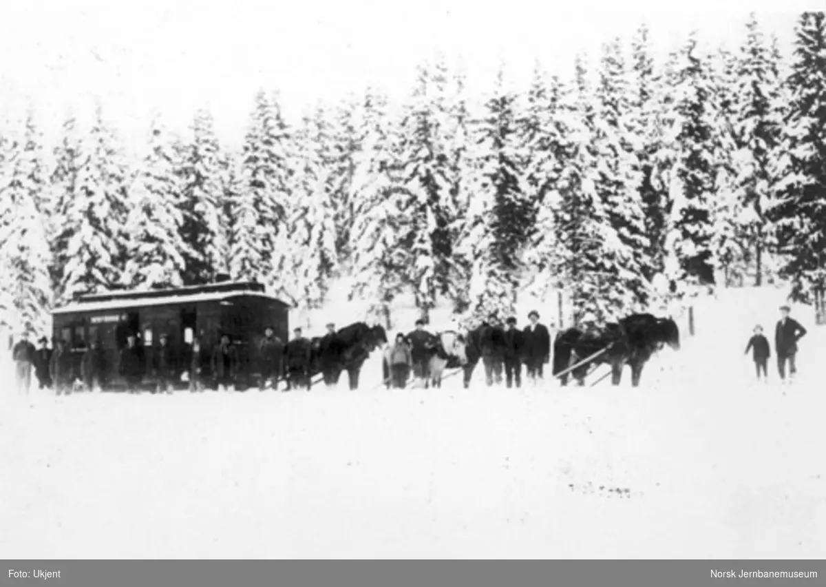 Vognkasse fra Hovedbanen under flytting på snøføre, trekkes av seks hester