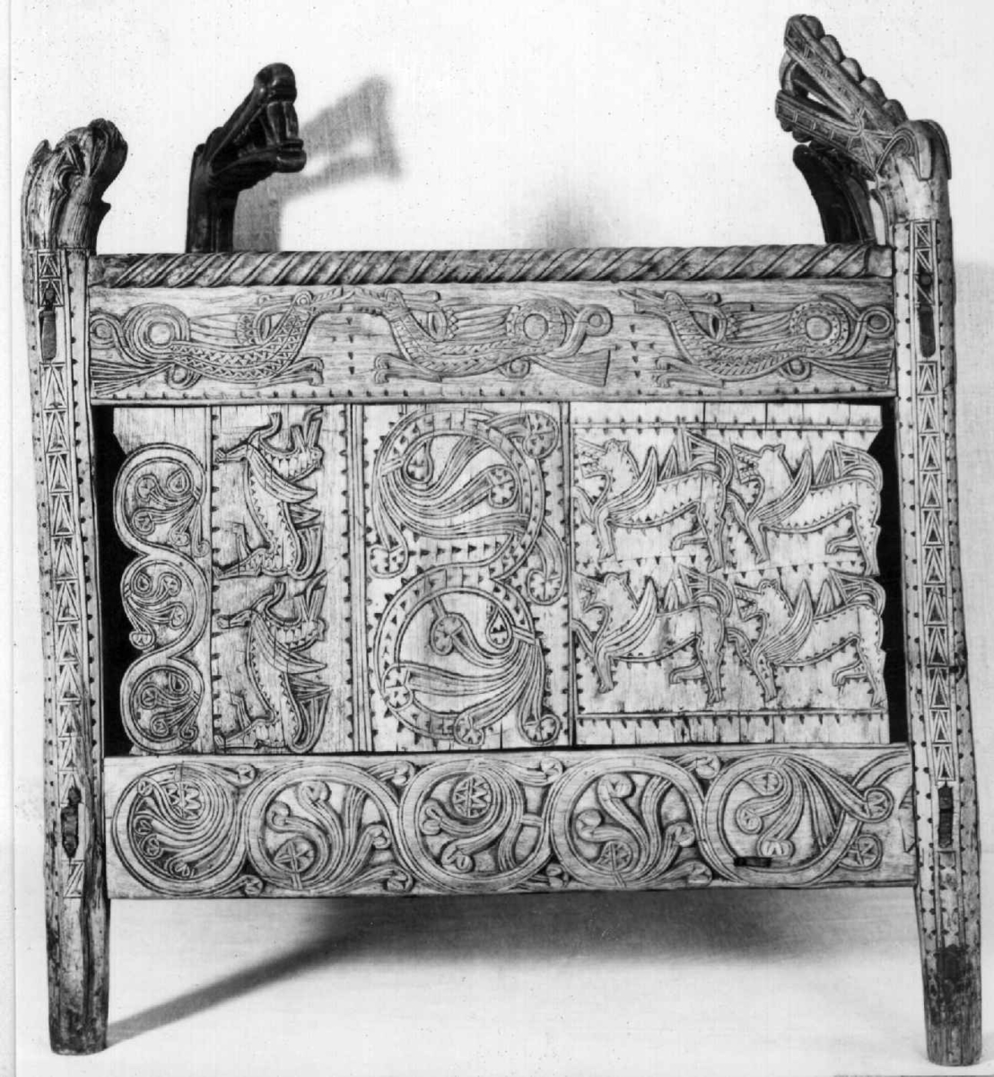 Fire søyler med skåret dyrehode-ornamentikk, sammenføyet med tverrbord og fyllinger. Bunn er åpen foruten to tverrstaver. Hele utsiden er rikt dekorert med utskåret dyr og ranker.