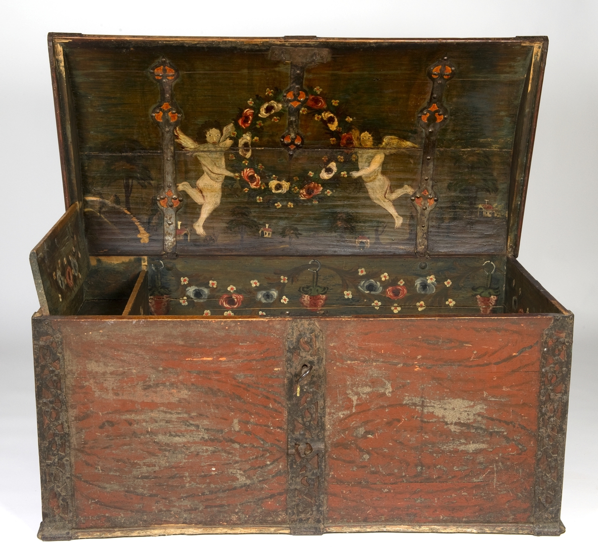 Kiste med buet lokk og gjennombrudte jernbeslag og bånd. Utvendig ådret og med initialer og årstall på baksiden. Innvendig bemalt med to engler og små hus i lokket.