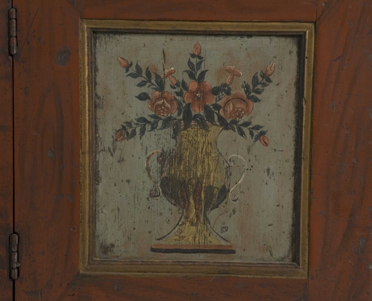 Doble dører oppe, to skyvedører på midten, en dør nede og to skuffer. Malte moriver: to adelsmenn og to blomster med nakne figurer oppi. Samson og løven på nedre skapdør. Marmorering i nisjen. Skyvedørene er dekorert med hester, kuer og geiter samt hus og en kirke.