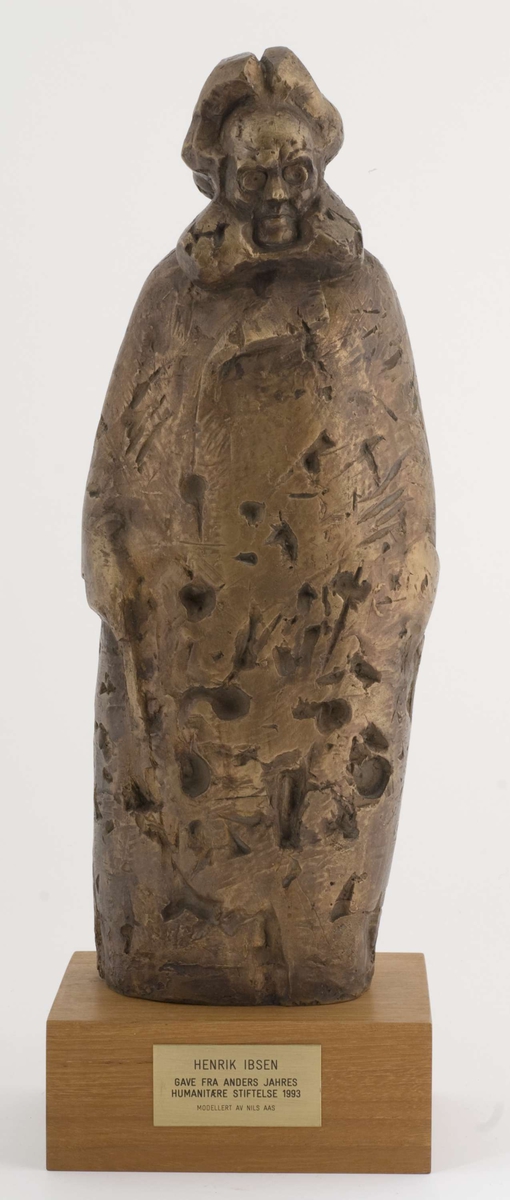 Metallskulptur på tresokkel, plakett på sokkel.