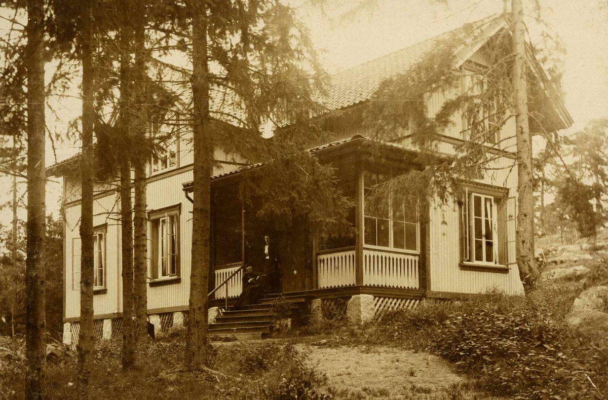 Villa Granli på Hankø. Eksteriør av trehus med glassveranda mellom trær.