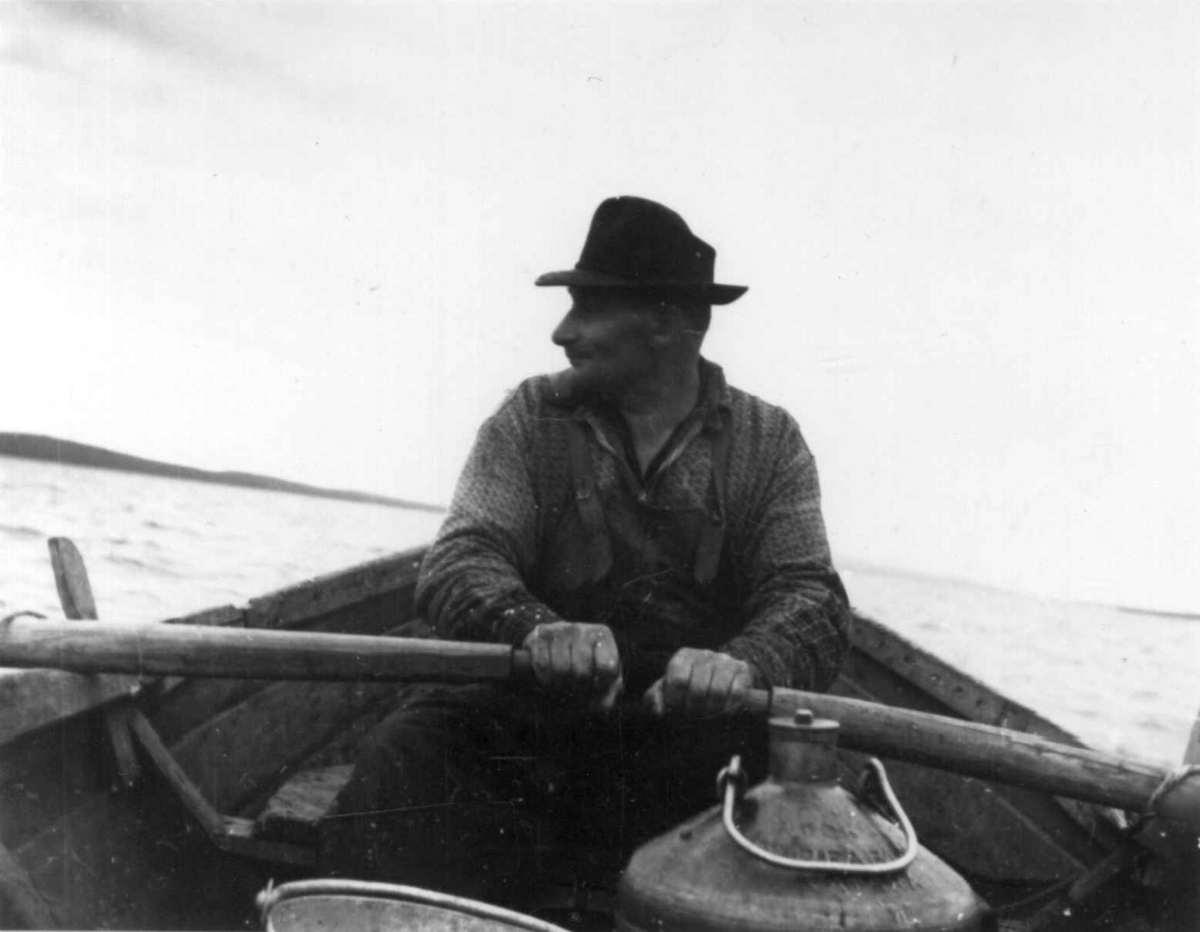 Notdraing. En mann sitter i båt og ror. Ålloluokta 1948.