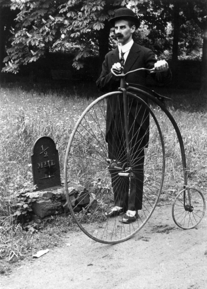 Sykkelkavalkaden i 1953. Mann i tidsriktig drakt med sykkel av typen "Veltepetter" i friluftsmuseet.