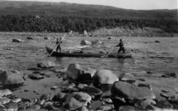 To personer i båt staker seg frem i Ailestrykene 1933.