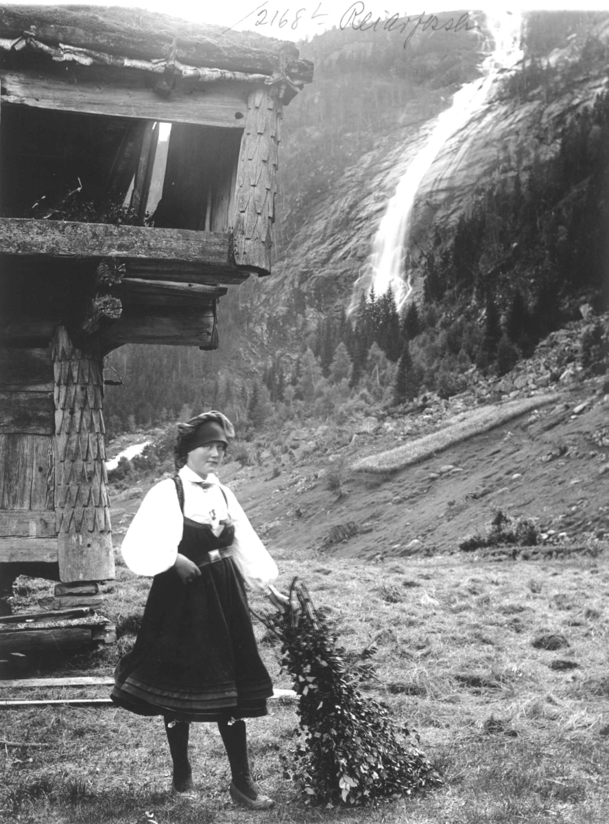 Jente i folkedrakt ved Reiarsfossen i 1888.