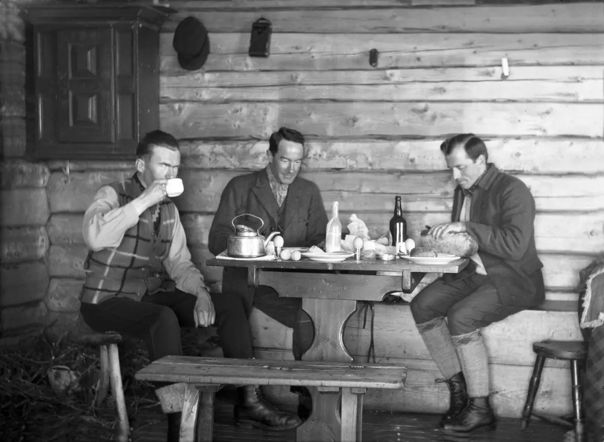 Fritjof Arentz, Sigurd Mørch og Bernt Jebsen spiser frokost i av husene på Trøan. Fotografert påsken 1929.
