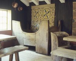 Middelaldermøblement med et åkle på veggen, kubbestol og ben