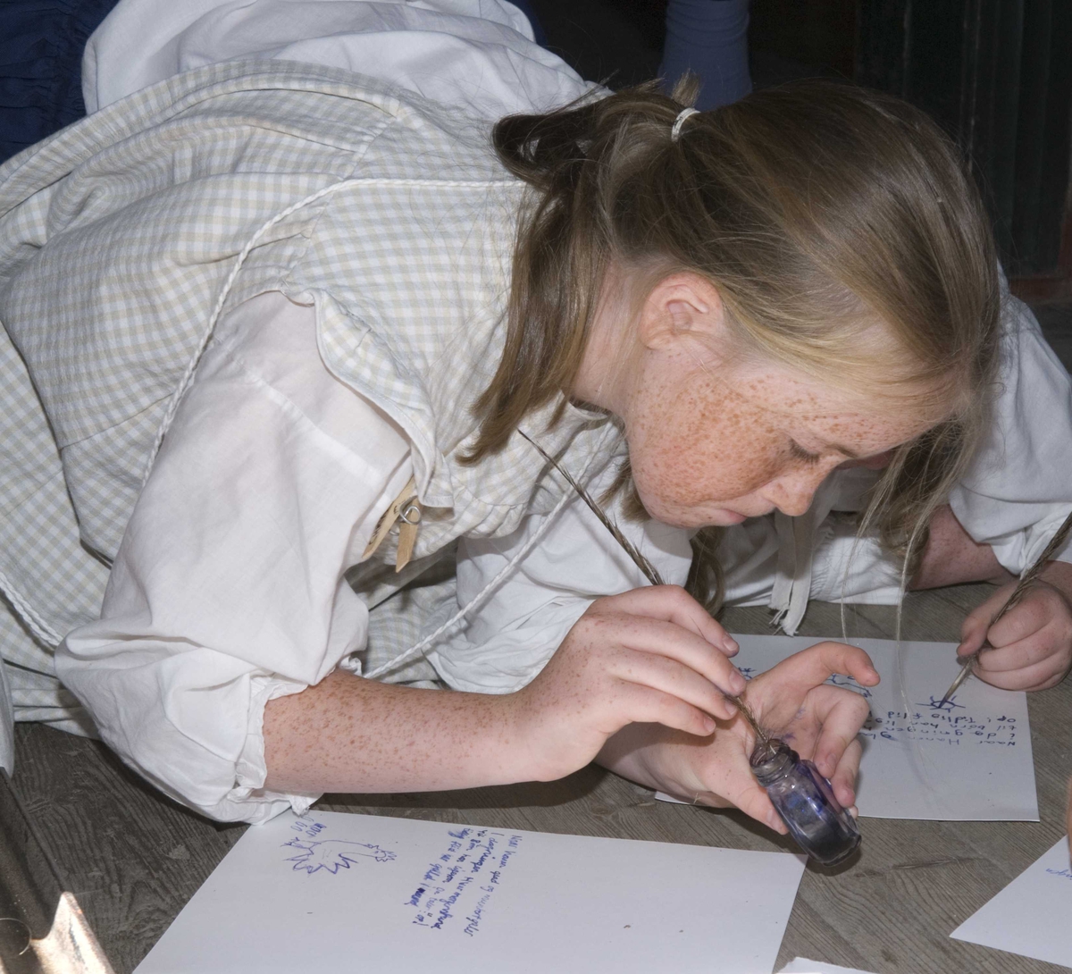 Levendegjøring på museum.
Elevene tegner og skriver med fjærpenn, Ferieskolen uke 30 i 2008.