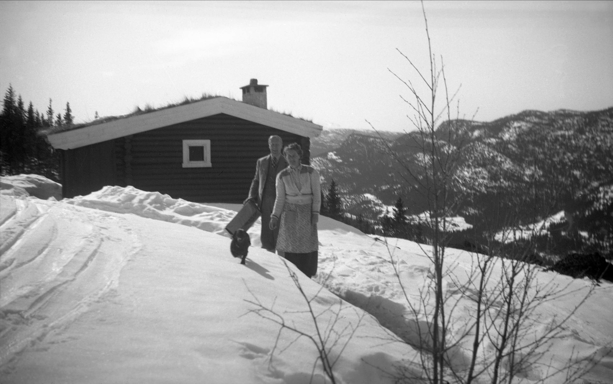 Klara og Sverre Ramstad foran badstua, antagelig på Arentz-familiens feriested Ligardshaug. Fotografert påsken 1950.