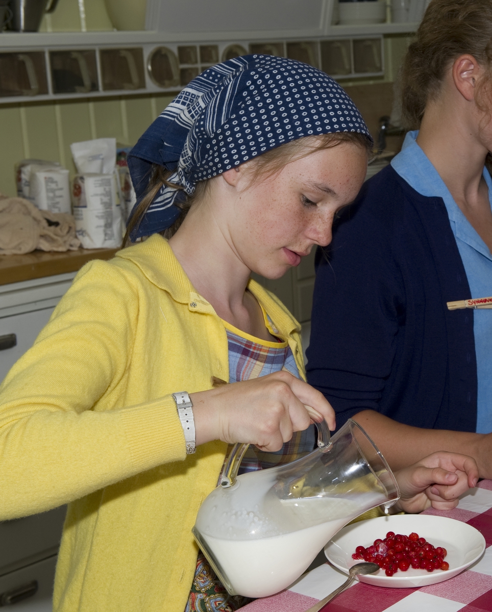 Jente spiser rips med melk. Trønderskolen anno 1959. Norsk Folkemuseums sommertilbud til ungdom. Deltakerne prøver seg på praktiske arbeidsoppgaver som det var vanlig at ungdom deltok på for 50 år siden. Trøndelagstunet på Norsk Folkemuseum, uke 31 2012.