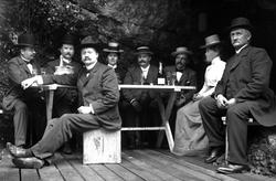 Gruppe mennesker stående på plattform/brygge i tre. Fjell/be