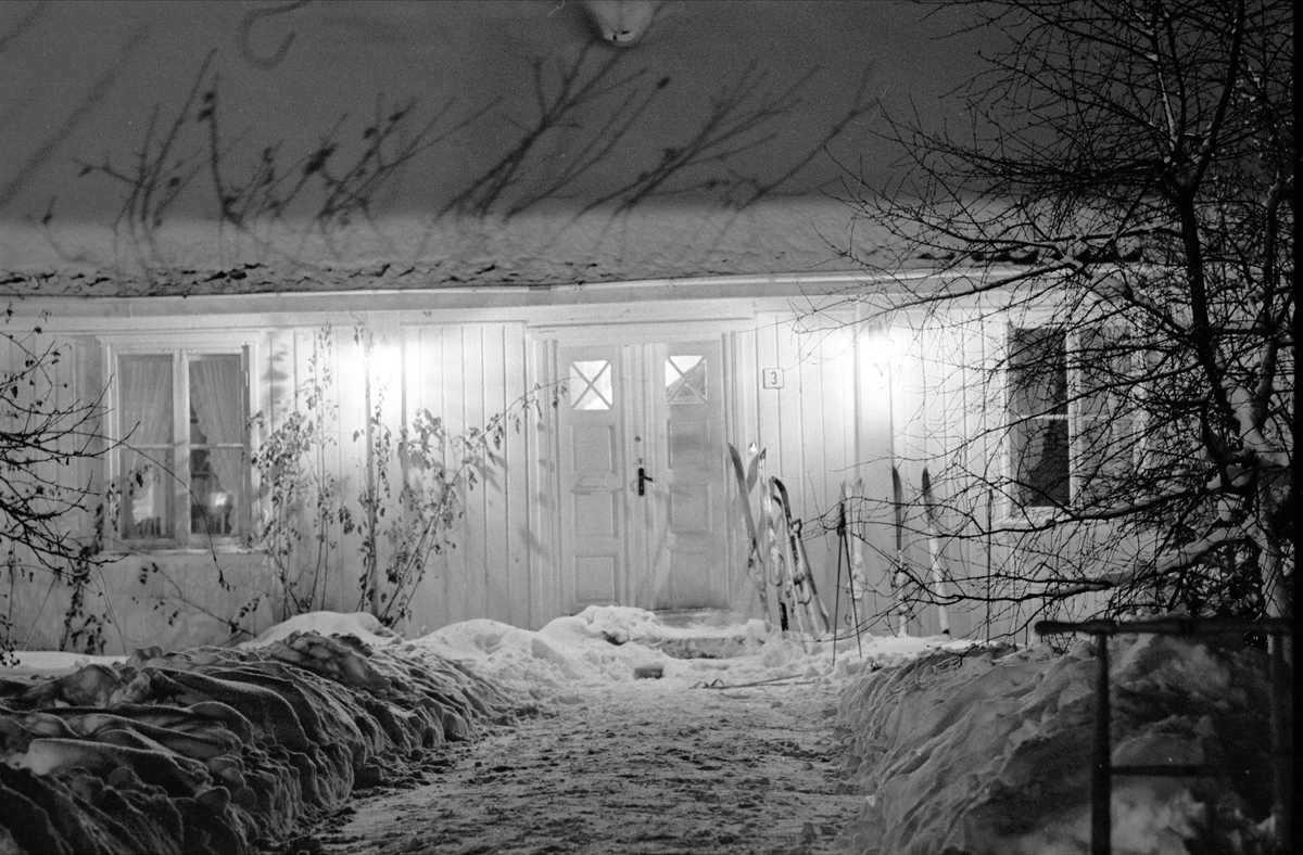 Bevaring av "det gamle Drøbak", Frogn, februar 1970. Ski ved inngangsdør til bolig. Bybilde med snø. Trehusbebyggelse.