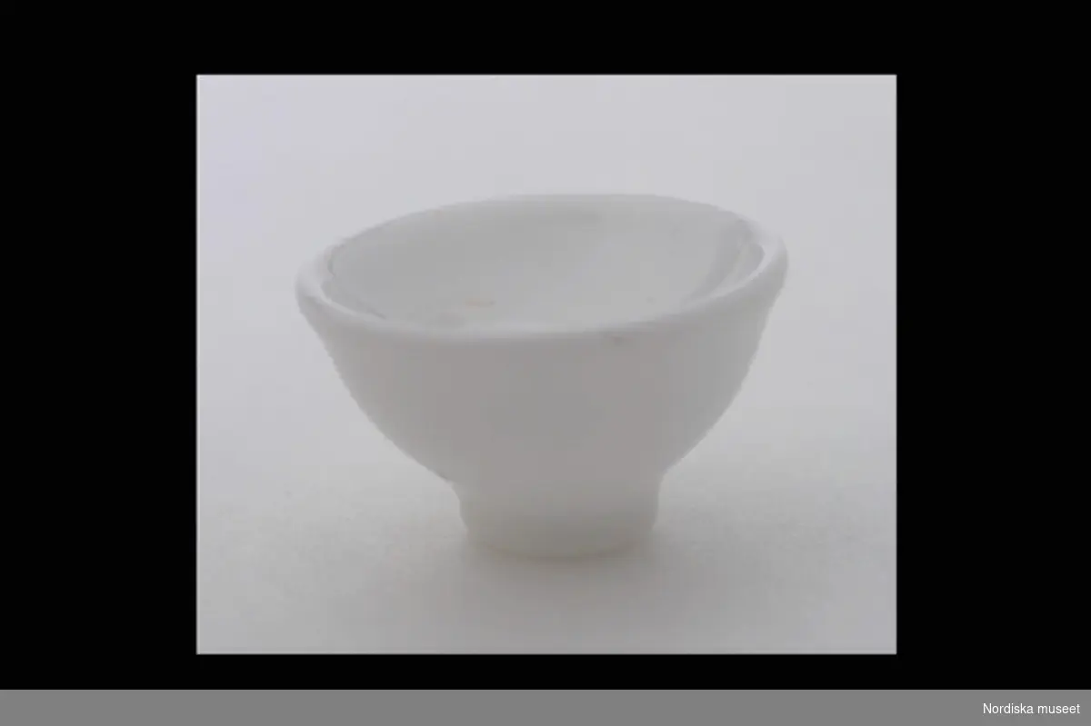 Inventering Sesam 1996-1999:
Diam  2,6 (cm)
Handfat, till dockskåp, av opalglas, skålformat, på fotring.
Tillhör dockskåp inv.nr 193.059. Skåpet är ritat år 1880 av givarinnans far, som lät en snickare tillverka det.
Anna Womack okt 1997