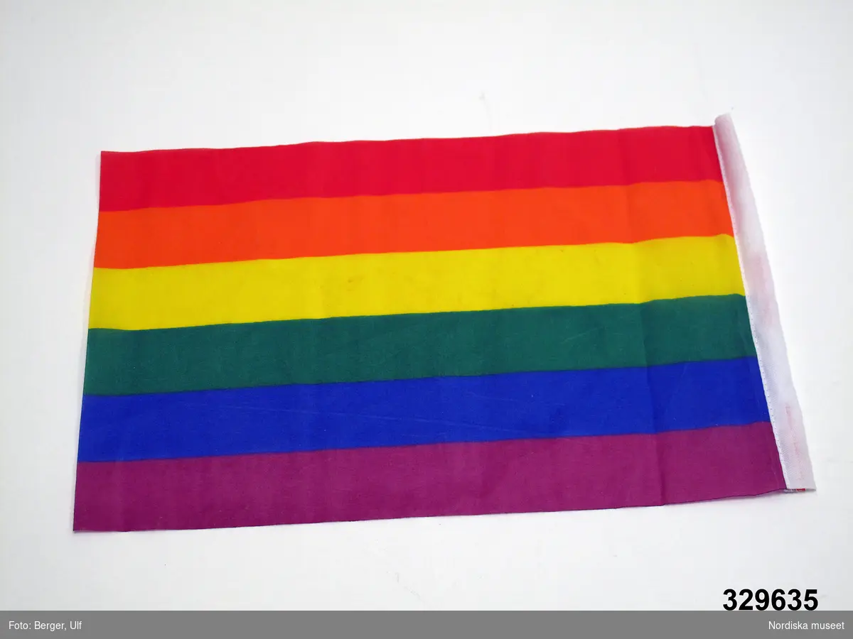 Flagga, Regnbågsflagga, av syntetmaterial. Tryck av horisontella ränder i färgerna (uppifrån): rött, orange, gult, grönt, blått och lila. på en kortsidan påsydd kanal av vitt tyg

Flaggan har använts av HBT-socialdemokraterna Stockholm vid deras deltagande i Stockholm Pride / Europride 2008 i Stockholm, vilket är den störrsta årliga festivalen för HBT-personer i Sverige och 2008 firades 25 jul-3 aug. Denna flagga var en av de likadana flaggor som användes av att pryda de fyra tält som HBT-socialdemokraterna hade i Pride Park (Tantolunden) och som dekoration på lastbilen som användes när man deltog i den stora paraden som går genom Stockholm under Pridefirandet. 

Flaggan är en Regnbågsflagga och är en symbol för mångfald, ofta använd av homosexuella, bisexuella, transpersoner med flera. Regnbågsflaggan står även för respekt för medmänniskor och tolerans. Flaggan skapades i USA av den amerikanske konstnären Gilbert Baker 1978 och har sedan spridit sig världen runt. Enligt vissa uppgifter ska den första varianten vara skapad av Anders Holmquist, som ville göra en multietnisk flagga med inspiration från den amerikanska flaggan där han bytte ut de röda ränderna mot regnbågsfärgade fält istället. Flaggan togs sedan över av Gayrörelsen/Gilbert Baker. (SVD Nätupplaga 2006-06-12 och dödsruna över A. Holquist i DN 2008-11-29)

Föremålet ingår i Nordiska museets dokumentation av Europride 2008 med föremål, intervjuer och fotografier. Se arkivet D.457 med bl.a. referat från intervju med  ordförande och kassör för HBT-socialdemokraterna Stockholm.
/Leif Wallin 2009-03-11