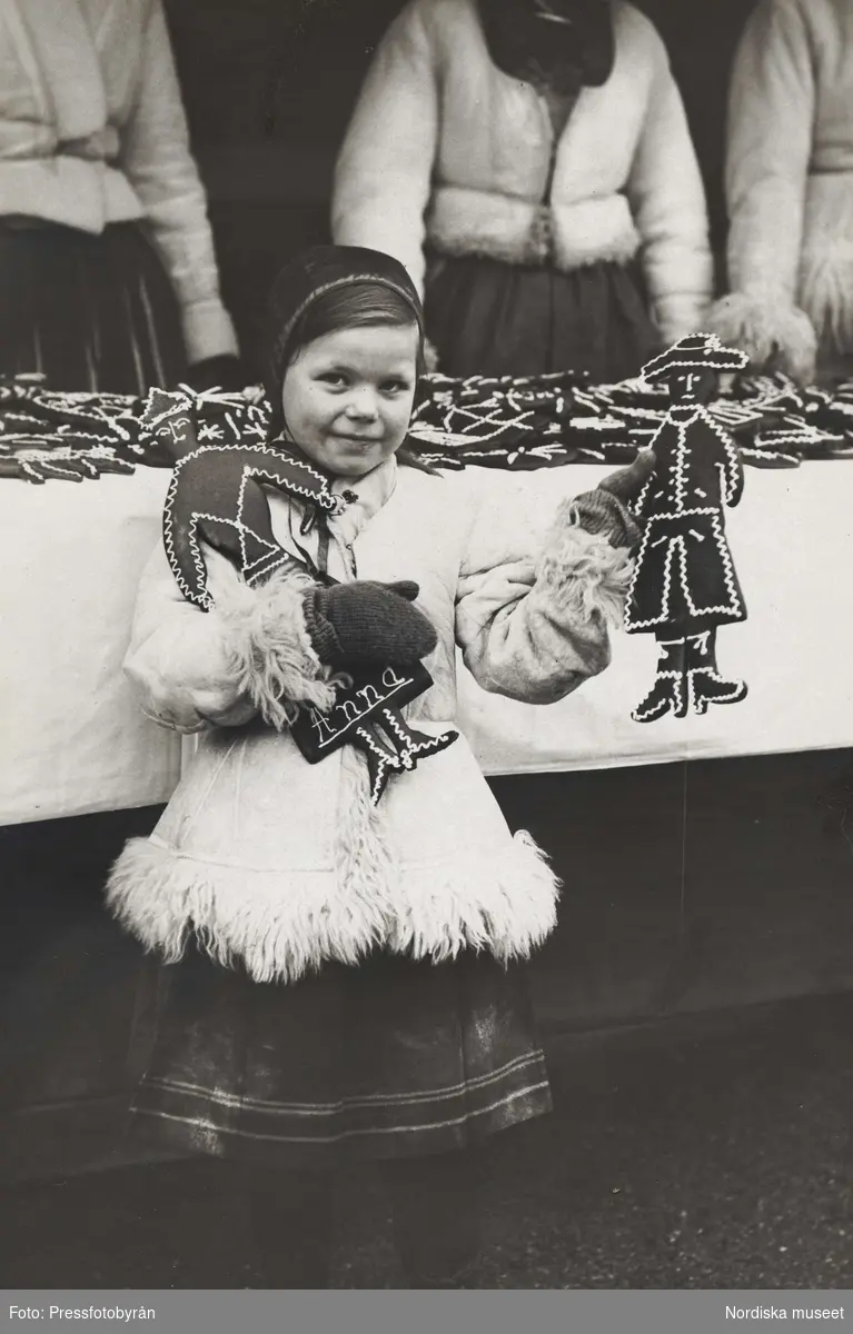 Flicka (Maj Lister) med pepparkakor i händerna. Skansens julmarknad 1923.