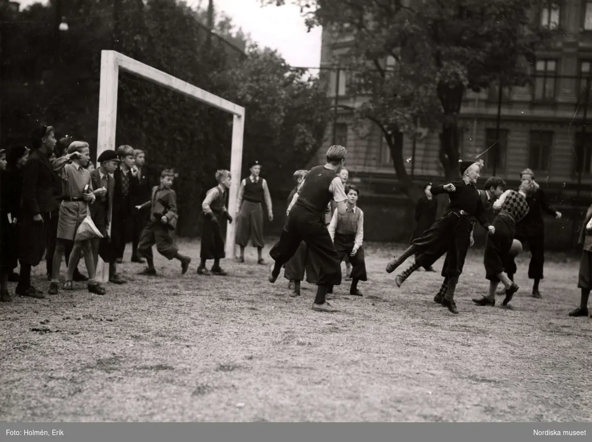 Reklam för skolkläder, Nordiska Kompaniet, 1941. Ett gäng pojkar spelar fotboll på skolgården.