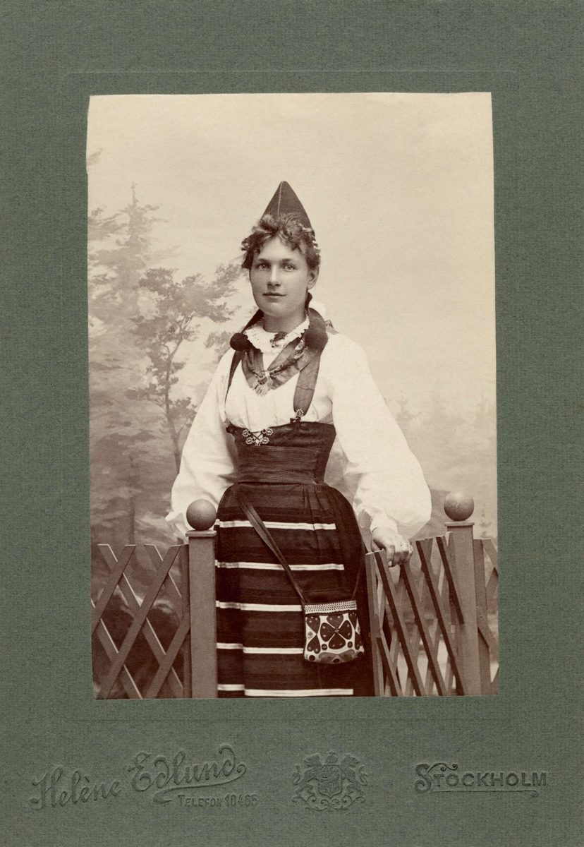 En kvinna poserar i folkdräkt från Rättviks socken i Dalarna.